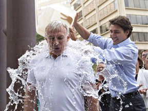 Liberal Leader Justin Trudeau pours ice water on the head of MP Sean Casey for the ALS ice bucket challenge during a break at the federal Liberal summer caucus meeting in Edmonton Tuesday.