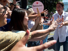 Liberal Leader Justin Trudeau, right, greets spectators during the Vancouver Pride Parade in Vancouver, B.C., on Sunday, August 3, 2014. Organizers expected more than half a million people to take in the parade which is one of the largest in North America. THE CANADIAN PRESS/Darryl Dyck