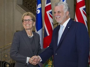 Ontario Premier Kathleen Wynne, left, shakes hands with Quebec Premier Philippe Couillard Thursday, August 21, 2014 at the premier's office in Quebec City.