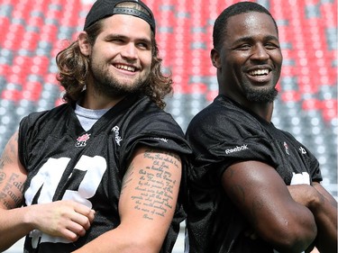 Linebackers Travis Brown (left) and Jasper Simmons try to keep straight faces while striking tough guy poses after practice.  Ottawa Redblacks run through a light practice Thursday, August 14, 2014 at TD Place stadium before Friday night's home game against the Edmonton Eskimos.  (Julie Oliver / Ottawa Citizen)