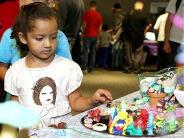 Maryame Bakirni, 6, looks stat various clay-type models during the Ottawa Maker Faire being held at the Canada Science and Technology Museum on August 17, 2014.