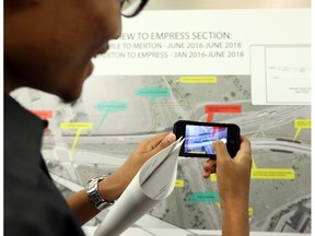 Michael Nhem takes a picture of a map during the information session about the detour off the Transitway from Tunney�s Pasture to downtown onto Scott and Albert streets at Tom Brown arena in Ottawa, June 16, 2014. (Jean Levac / Ottawa Citizen)