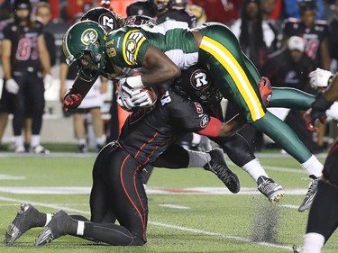 Ottawa defensive back Eddie Elder heaves Edmonton's Devon Bailey into the air during a key tackle in the first half during the Ottawa Redblacks Friday night matchup against the Edmonton Eskimos at TD Place in Ottawa, August 15, 2014.