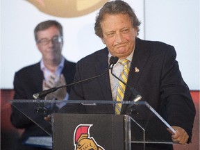 Ottawa mayor, Jim Watson, left, looks on as Ottawa Senators' owner, Eugen Melnyk, speaks during a press conference to announce a major community fundraising milestone for the Ottawa Senators Foundation at Canadian Tire Centre Tuesday, August 19, 2014. The foundation has raised over $100 M in community charity.