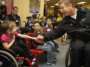 Rick Hansen (R) shakes hands with Ashley during the  Rick Hansen's Relay Day # 65 at the Ottawa Children�s Treatment Centre, October 27, 2011. (Photo Jean Levac, Ottawa Citizen)  CITY Assignment  106429