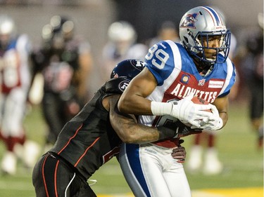 Jovon Johnson #2 of the Ottawa Redblacks grabs a hold of Duron Carter #89 of the Montreal Alouettes during the CFL game at Percival Molson Stadium on August 29, 2014 in Montreal.