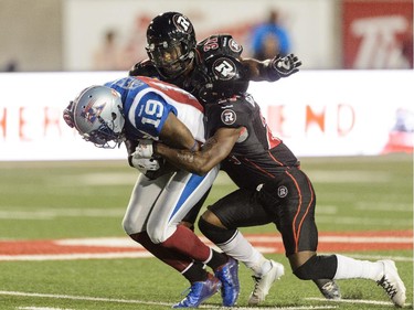 Jerrell Gavins #24 of the Ottawa Redblacks tackles S.J. Green #19 of the Montreal Alouettes.
