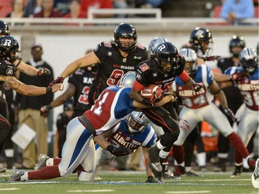 Chip Cox #11 of the Montreal Alouettes holds onto Jamill Smith #15 of the Ottawa Redblacks during the CFL game at Percival Molson Stadium on August 29, 2014 in Montreal.