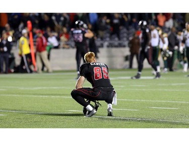 Ottawa's Matt Carter - who got the ball knocked out from his grip by Edmonton's Alonzo Lawrence in the dying minutes of the game - sits midfield alone after the Redblacks lost 10-8.   Ottawa Redblacks Friday night matchup against the Edmonton Eskimos at TD Place in Ottawa, August 15, 2014.