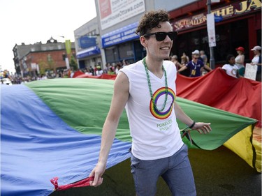 Participant in the Capital Pride Parade carries a giant pride flag as they march on Bank St. on Sunday, Aug. 24, 2014.