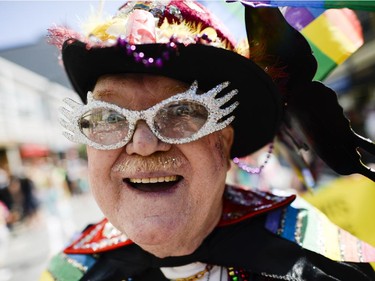Participant in the Capital Pride Parade smiles for the camera as they march on Bank St. on Sunday, Aug. 24, 2014.