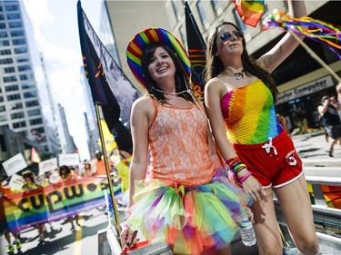 Participants at the Capital Pride Parade wave at the crowd as they march on Laurier Ave. on Sunday, Aug. 24, 2014.