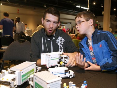 Paul Camire (L), Parlugment, and Christopher Henderson (R), 7, discuss Lego trucks during the Ottawa Maker Faire being held at the Canada Science and Technology Museum on August 17, 2014.