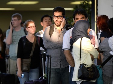 People wait in a queue at the Ottawa Train Station as Via Rail service was disrupted following a derailment near Ganaoque on Friday, August 1, 2014.