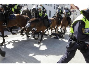 Police mounted on horses ride through counter-demonstrators protesting against an election meeting arranged by the neo-nazi party "Svenskarnas Parti", at a square in central Malmo, Sweden, Saturday, Aug. 23, 2014. Two people were reportedly injured. There were several thousand protesters, while the party meeting totaled less than a hundred sympathizers.