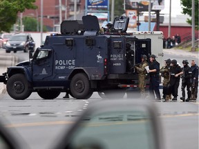 Emergency response officers wait outside a residence in Moncton, New Brunswick, Thursday, June 5, 2014, searching for a suspect who shot and killed three Royal Canadian Mounted Police officers the day before.