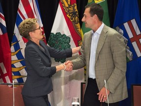 Ontario Premier Kathleen Wynne, left, and Prince Edward Island Premier Robert Ghiz shake hands at the closing news conference of the annual Council of the Federation meeting in Charlottetown on Friday, August 29, 2014.