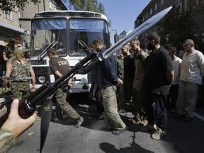 Pro-Russian rebels escort captured Ukrainian army prisoners in a central square in Donetsk, eastern Ukraine, Sunday, Aug. 24, 2014.