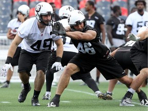 Redblacks John Delahunt,  49, Jason Pottinger, 46, and Connor Williams, 99, work on defensive zone coverage.