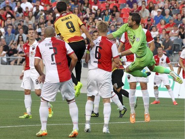 Romuald Peiser #1 of the Ottawa Fury pouches the ball away against Martin Nuñez #9 of the Fort Lauderdale Strikers during an NASL match at TD Place in Ottawa on August 9, 2014.