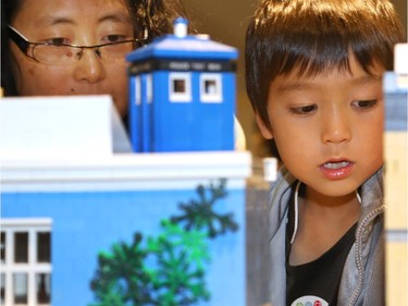 Selens Tsai (L) and her son, Alexi Raymond Tsai (R), 6, gets a closer look at the intricate lego buildings during the Ottawa Maker Faire being held at the Canada Science and Technology Museum on August 17, 2014.