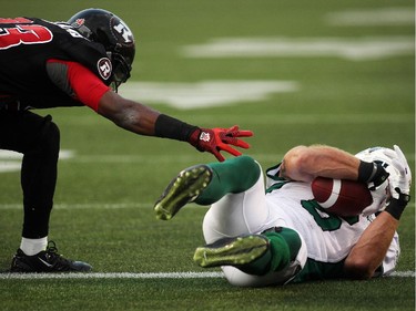 Seth Williams of the Ottawa Redblacks reaches for the ball in possession of the Saskatchewan Roughriders' Rob Bagg at Ottawa's goal line during the first half of CFL game action at TD Place in Ottawa on Saturday, Aug. 2, 2014.