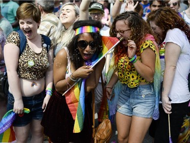 Spectators react as they are sprayed with water during the Capital Pride Parade on Bank St. on Sunday, Aug. 24, 2014.