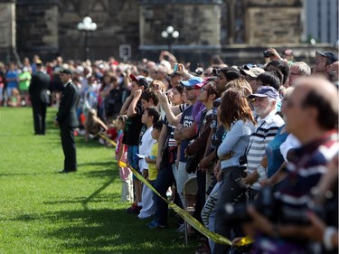 Spectators watch as the Ceremonial Guard performs on Parliament Hill one last time on the last performance of the season, Saturday, Aug. 23, 2014.