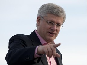 Canadian Prime Minister Stephen Harper gestures toward cameras as he prepares to leave Whitehorse on Friday August 22, 2014.