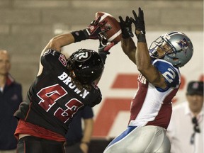 Ottawa Redblacks linebacker Travis Brown intercepts a pass intended for Montreal Alouettes running back Brandon Whitaker during second quarter CFL football action Friday, August 29, 2014 in Montreal.