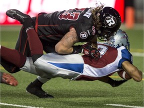 Montreal Alouettes running back Brandon Whitaker is tackled by Ottawa Redblacks linebacker Travis Brown during second quarter CFL football action Friday, August 29, 2014 in Montreal.