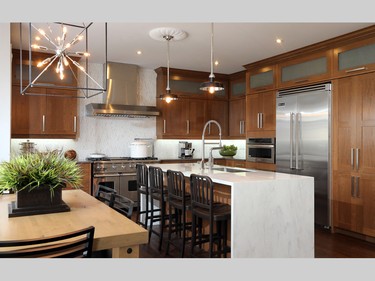 In the kitchen, Shaker-style cherry cabinets in a wheat stain are balanced by an off-white Corian waterfall counter on the island and a subtle marble backsplash in a chevron pattern. A plethora of professional appliances, including a six-burner gas stove, complete this gourmet kitchen.