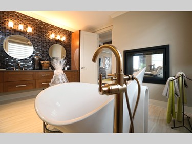 In the master ensuite, a two-way fireplace looking into the bedroom adds to the spa-like feel, along with the rich vanity backsplash in matte and glossy finishes and the sculptural standalone tub.