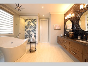 On the other side of the master ensuite, a mosaic tile in the five-foot shower adds a touch of whimsy, while the pendant over the tub echoes ones found above the basement bar island, once again combining the different decor styles.