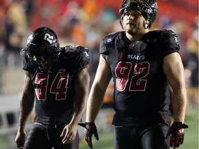 Michael Hayes and Zack Evans of the Ottawa Redblacks walk back dejected after a home loss.
