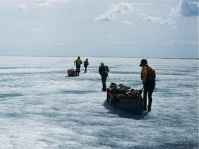 Jennifer Kingsley and her colleagues drag loaded boats over a frozen lake.