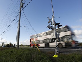 A double-decker bus drives over the railway crossing at Woodroffe Avenue near Fallowfield Station a year to the day after the bus-train collision at the crossing that killed six people.