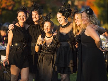 A group of women pose for a photo, bathed in the light of a setting sun, at the 2014 Harvest Noir picnic, Sept. 27, 2014.