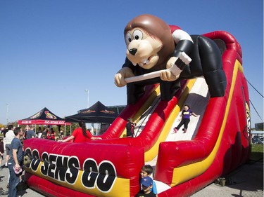 A young girl slides down an inflatable slide at the Ottawa Senators Fan Fest at Canadian Tire Centre, Saturday, Sept. 27, 2014.
