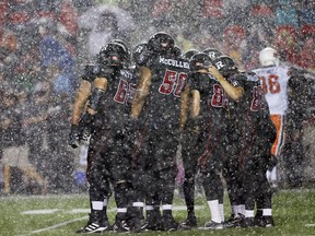 The Ottawa Redblacks huddle in the rain against the BC Lions during second half action at TD Place in Ottawa, September 5, 2014.