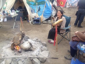 Audrey Redman sings around the sacred fire at a contested archeological site in Gatineau on Wednesday.