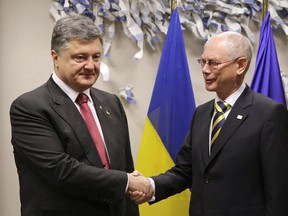 President of the European Council Herman Van Rompuy, right, shakes hands with Ukrainian President Poroshenko before a recent meeting at EU Headquarters. Poroshenko will be in Ottawa Wednesday.