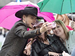 Brett Kissel stops for a selfie with fans as he makes his way down the green carpet during the Canadian Country Music Association awards in Edmonton.