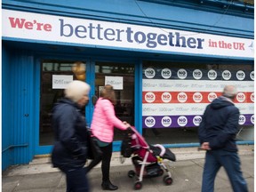 People walk past a "Better Together" pro-union campaign shop in Edinburgh on September 9, 2014, ahead of Scotland's independence referendum.