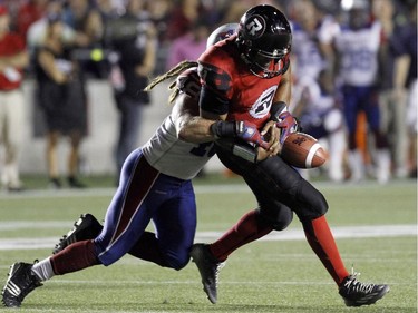 Ottawa Redblacks' Henry Burris loses the ball as he is stopped by Montreal Alouettes' Bear Woods (48) during CFL football action in Ottawa, Friday September 26, 2014.
