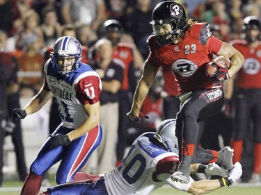 Ottawa Redblacks Jonathan Williams (23) goes in for a touhdown as he avoids a tackle by Montreal Alouettes Marc-Oliver Brouillette (10) as Chip Cox (11) looks on during CFL football action between the Ottawa Redblacks and the Montreal Alouettes in Ottawa, Friday September 26, 2014.