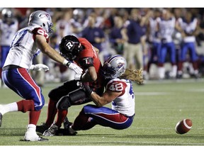 Ottawa Redblacks Henry Burris (1) loses the ball as he is grabbed by Montreal Alouettes Bear Woods (48 ) last Friday at TD Place.