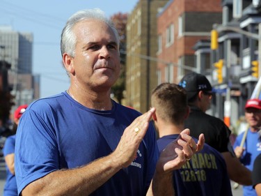 Chief Charles Bordeleau claps as runners participating in the National Peace Officers Memorial Run run past police headquarters on Elgin St. downtown Ottawa, Saturday, September 27, 2014. Bordeleau joined the officers for the final 3km to Parliament Hill. Hundreds ran 460km from Toronto to Ottawa, past Ottawa Police headquarters then up Elgin to Parliament Hill.