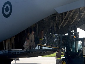 Canadian and Czech soldiers load boxes containing ammunition into the Canadian C-17 Globemaster III plane that will carry them to Iraq, at the Pardubice military airport, central Czech Republic. Canada will also buy robots to help defuse bombs.