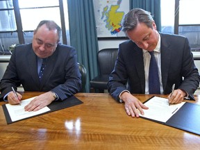 This is an Oct. 15, 2012  photo of Britain's Prime Minister David Cameron, right, and Scotland's First Minister Alex Salmond, signing a referendum agreement during a meeting at St Andrews House in Edinburgh.  Salmond resigned after the referendum on Sept. 18, 2014.